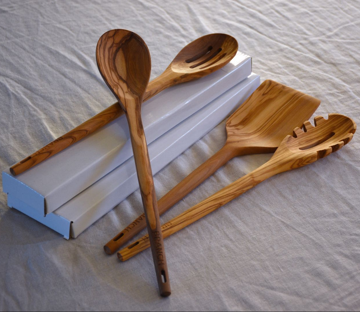 Set of wooden cooking utensils on a textured surface